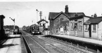 A view northwards at Brock in the 1930s as a <I>Royal Scot</I> class 4-6-0 approaches on a passenger train that also seems to be conveying milk tanks. Comparison with the earlier picture [See image 23684] shows that the signal box has moved from down to up side and the down starter has been replaced by an upper quadrant signal. Just behind that some goods wagons sit in the siding alongside the down line. The stone station building dates from the construction of the line by the L&PJR with the wooden buildings and platforms being later LNWR additions. Photo credited to D. Thompson. <br><br>[Rev Ron Greenall Collection //]