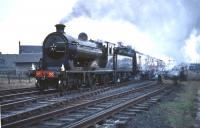 <I>Scottish Rambler No 3</I> on the level crossing at Kincardine station on 30 March 1964 behind ex-NBR no 256 <I>Glen Douglas</I> on its way from Dunfermline Upper to Alloa. The northern approach to the Kincardine Bridge can be seen in the right background.<br><br>[Robin Barbour Collection (Courtesy Bruce McCartney) 30/03/1964]