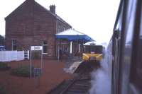 Looking eastward at Dalmally station in 1985 from the window of a class 37 hauled service heading for Oban, with steam heat working even in August. The class 104 'Mexican Bean' is in the eastbound platform on an Oban to Crianlarich shuttle service.<br><br>[John McIntyre /08/1985]