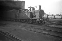 Fowler 3F no 47668 stands on Camden shed in October 1959. In the background, partially hidden by the locomotive's smokebox, is the old roundhouse built by the London & Birmingham Railway in 1846. Although only used to house locomotives until 1867, the roundhouse still survives and stands today as a well known arts and entertainment centre on Chalk Farm Road.<br><br>[Robin Barbour Collection (Courtesy Bruce McCartney) 04/10/1959]