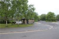 There are still a few clues here that this was once the site of the terminus station on the Hayfield branch from New Mills. The station used to be to the left of the building in the photo (now a car park)as we look towards New Mills. Just to the right of the building in the distance is a gate on the former trackbed which is now the start of the Calico Trail.<br><br>[John McIntyre 13/05/2009]
