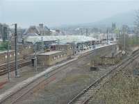 View over Skipton on a cold misty morning in April 2009, from the road overbridge at the north end of the station. A Class 333 EMU is about to leave for Leeds from the platform by the main station building and another for Bradford stands in the bay beyond. In the foreground is the former Grassington branch that still carries regular limestone trains and passes through the platforms that were also used for Ilkley line trains. The nicely restored canopies are clearly visible as are the three substantial subway entrances to the platforms.<br><br>[Mark Bartlett 16/04/2009]