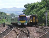 An Aberdeen express passes a recessed <i>Fife circle</i> Class 150 at Dalmeny on 21 August 2004.<br><br>[James Young 21/08/2004]