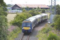 170 394 traverses the Inverkeithing North/East chord en route from Dunfermline to Kirkcaldy, stopping at Dalgety Bay to transfer passengers to/from buses to Edinburgh, on 12 July.  A track machine is stabled in Inverkeithing yard in the background.<br><br>[Bill Roberton 12/07/2009]