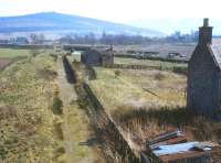 View north over Cromdale in April 1984, almost 16 years after complete closure of the line. If you look very closely behind the station buildings you can just make out the profile of the cutting to the Balmenach Distillery. (Railscot note: Much restoration work has taken place at the former Cromdale station since this photograph was taken [see image 1141]).<br>
<br><br>[Peter Todd 12/04/1984]