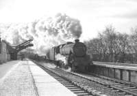 <I>'Twas a cold and frosty morning.... </I>  A chilly-looking scene on the platform at Riddings Junction in November 1964 as one of Kingmoor's Black 5s, no 45481, thunders north through the station with the lengthy 11.15am Carlisle Yard - Millerhill express freight. Note the changeover between bullhead and flat-bottom rail at this point. <br><br>[Robin Barbour Collection (Courtesy Bruce McCartney) 28/11/1964]