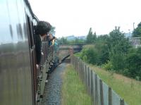 Crossing <I>the hump</I>. As part of the ELR extension from Bury to Heywood in the 1990s, a bridge was built to span the Metrolink tracks from Bury Interchange, requiring trains between Bury Bolton Street and Heywood to tackle a 1 in 36 gradient in order to cross the busy route from Manchester Victoria. The bridge is referred to locally as <I>the hump</I>. The photograph is taken from the window of a train heading west towards Bolton Street on the ELR behind 55022 <I>Royal Scots Grey</I> as it traverses the <I>hump</I> on 5 July 2009.  (The bridge stands on the site of the former Bury Knowsley Street station, where, for at short period in the early 1980s, following the opening of the new Bury Interchange station, a flat crossing existed.) [See image 45436]<br>
<br><br>[Colin Alexander 05/07/2009]