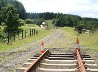 The southern extent of the WRHA track at Whitrope, seen on 10 July 2009. The line stops just short of bridge 200 (the Golden Bridge) over the B6399 road to Newcastleton. A snow plough stands in the background alongside the trackbed which is about to enter a cutting as it runs south towards Riccarton Junction.<br>
<br><br>[John Furnevel 10/07/2009]