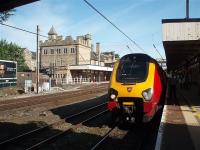 221116 is just about to depart Lancaster for Birmingham New Street. In the background the impressive down side buildings of the station, formerly known as Lancaster Castle, can be seen as can the Up and Down through roads. These non-platform lines are still frequently used by WCML freight traffic. <br><br>[Mark Bartlett 31/07/2009]