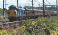 Lineside vegetation is taking a hold again after it was extensively cut back last year when a new fence was installed on the west side of the WCML at Euxton Junction. The peace of the countryside is shattered on a Sunday afternoon as a pair of Class 37 locos speed north to Carnforth with the ecs from the previous days Spitfire railtour. So loud are these veteran locos that they drowned out the heavy Sunday traffic on the M6, some 200 m behind the photographer. Now that was a result!<br><br>[John McIntyre 02/08/2009]