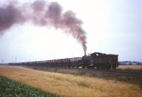 One of the ubiquitous J27s that plied the Blyth and Tyne in the 1960s, North Blyth shed's no 65811, seen here hauling coal empties between Freeman's crossing and Winning Junction. The power station chimneys and lighting towers are visible through the murk beyond the train.<br>
<br><br>[Robin Barbour Collection (Courtesy Bruce McCartney) //]