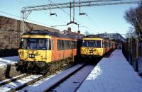 Class 303 and 311 EMUs at the Neilston terminus in February 1985. The visit was notable because of the effort it took to pay my fare. The ticket office clerk initially waved me away, saying that my destination was unmanned and no one would be checking on the train!<br><br>[Mark Dufton /02/1985]