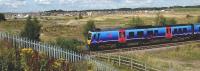 A Manchester Airport bound First TransPennine Express service is seen passing the site of the planned Buckshaw Parkway station which has now received the full funding to see the area developed as a transport hub. A part of the extensive local housing development can be seen in the backgound<br><br>[John McIntyre 07/08/2009]