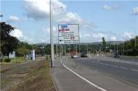 This road sign has been in place for over 3 years, although the station to which it is pointing has not yet been built! The extensive housing and industrial development on the site of the former Royal Ordnance Factory at Euxton/Chorley has been scheduled to have a new railway station for some time, but only in the first days of August 2009 was the final funding obtained to make the station a reality. The former ROF Admin Block to the left of the photograph is now an outstation of Runshaw College, Leyland. This along with the large number of houses on the adjoing estate should make this an attractive park and ride site for those travelling to Manchester and to the north.<br><br>[John McIntyre 07/08/2009]