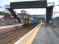 Standing under the particularly temporary-looking temporary footbridge at Murraw'll is 156 439, waiting to return to Cumbernauld with the hourly shuttle on Saturday 8 August 2009.The new bridge connecting Hamilton Circle platforms 3 and 4 nears completion in the background. This will be at least the fourth architectural style at this station with the only antique bit left being the stairway down to Platform 1 on the extreme left of the photograph.<br><br>[David Panton 08/08/2009]