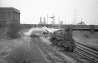 BR Standard class 4 no 76046 photographed just south of Renfrew Wharf around 1966, with Yoker power station dominating the skyline on the north side of the river. On the left is an old building carrying the name Simons Lobnitz, a renowned shipbuilder specialising in dredgers and hopper barges, whose products were deployed on major projects worldwide, including construction of the Panama Canal. Operations ceased here in 1964. The line to Renfrew Wharf lost its passenger service in 1967 with this section closing completely in 1978. <br>
<br><br>[Robin Barbour Collection (Courtesy Bruce McCartney) //1966]