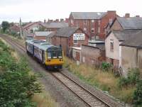 Running along the backs of the houses and shops 142007 slows for the stop at St Annes on a service for Blackpool South. The single line branch from Kirkham was relaid, along its entire length, with CWR in the late 1990s and so the ride is good, even in these Pacers. <br><br>[Mark Bartlett 11/08/2009]