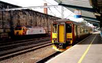 SPT liveried 156511 pauses on platform 1 at Carlisle having arrived from Newcastle on 16 September 2006. The service is heading north for stations on the G&SW main line. A Class 57 Thunderbird sits in the sidings on the west side of the station awaiting it's next duty.<br><br>[John McIntyre 16/09/2006]