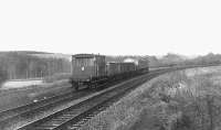 A Brush type 4 makes light work of a tanker, three wagons and a brake van heading north on the Waverley route near Riddings not long before final closure. The remains of the Langholm branch are over on the left.<br>
<br><br>[Bruce McCartney //]