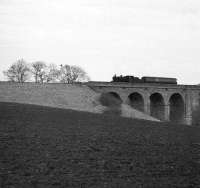 The 9.59am Berwick - St Boswells train, with locomotive 78047 in charge, about to leave the west end of Roxburgh Viaduct and run into Roxburgh station. The photograph was taken on 10 February 1964, the year passenger services were withdraw from the branch.<br><br>[Robin Barbour Collection (Courtesy Bruce McCartney) 10/02/1964]