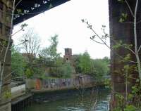 Looking across the River Kelvin at the location where a branch from the Lanarkshire and Dumbartonshire crossed the river from Partick Central to meet the network of lines around Pointhouse Quay and the Queen's Dock. Overhead is the viaduct of the Stobcross Railway. The scrapyard seen on the opposite bank has since closed and been cleared.<br><br>[Ewan Crawford 27/04/2003]