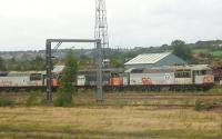 Grab shot, from a passing Wakefield to Huddersfield train, of three of the fifteen Class 56 locomotives still stored in Healey Mills yard in September 2009. They are a sorry looking bunch. Details of locomotives stored here and at other UK locations can be found at the excellent <I>End of the Line</I> website at www.wnxx.com (January 2010 update: The Class 56 locos stored in Healey Mills yard were removed this month for scrapping at various locations.) <br><br>[Mark Bartlett 04/09/2009]