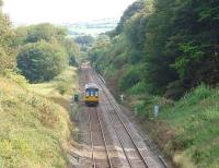 Pacer in the Lancashire countryside. Northern 142056, on a Colne service, has just topped Hoghton bank and is dropping down towards the River Darwen and Pleasington station. The hill rising very steeply on the right supports the fortified manor house known as Hoghton Tower.<br><br>[Mark Bartlett 07/09/2009]