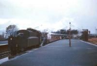 The last passengers alight from a boat train on a rainy day at Princes Pier, Greenock, in the mid sixties. Standard class 4 no 76114 stands ready to couple up at the rear and take out the empty stock. Scheduled passenger services had ceased to run to Princes Pier in February 1959 but the station continued to handle boat trains and specials until November 1965.  <br>
<br><br>[Robin Barbour Collection (Courtesy Bruce McCartney) 30/10/1965]