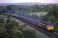 Green liveried 47522 <I>Doncaster Enterprise</I>, takes the Euston-Inverness Sleeper north through the Dunblane Laighills at 5.30 a.m. one morning in June 1988. This was a long and heavy train, carrying cargo such as newspapers as well as sleeping passengers. To obtain a similar photo today of the much shorter and faster Caledonian Sleeper, one would need to knock on someone's door and ask to stand in their kitchen at 5.15 a.m!<br><br>[Mark Dufton /06/1988]