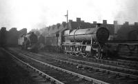 The large steam shed at Mollington Street, Birkenhead, complete with permanent haze, in September 1958. This large depot was a combination of two previously separate 8-road straight sheds originally belonging to the LNWR (left) and GWR, with a shared turntable and coaling stage. The shed closed to steam in 1967 but saw further use as a diesel depot until abandoned in 1985. The last of the buildings on the site was demolished in 1987.<br><br>[Robin Barbour Collection (Courtesy Bruce McCartney) 26/09/1958]