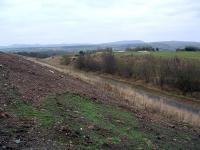 This view shows the Camps Branch running south towards Camps Viaduct. The land to the right of the railway trackbed, now a footpath, had been the Pumpherston Oilworks. It is now partly vacant and partly a golfcourse. The works had a slow decline with the crude works closed in the 1920s, refinery in 1964 and some parts in use until the late 1970s and even 1990s.<br><br>[Ewan Crawford 06/12/2003]