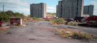 Pinkston Mineral Yard was a coal yard with a large fan of rails. It was still in use as a coal depot in 1987, when this photograph was taken, despite closure of the Port Dundas branch stub in 1983. Various sections of the branch and yard track remained as much of it ran on concrete aprons and cobbled streets. The branch served this coal yard, Pinkston Power station, various warehouses, Tennent's Wellpark brewery and the canal harbour at Port Dundas. The area was also served by the Caledonian Railway and the two systems met in the dock area. The view looks to the junction with the Edinburgh and Glasgow Railway at the head of the Cowlairs Incline with the old approach to Port Dundas running off to the left and reaching Port Dundas and Pinkston Power station via a reversal.<br><br>[Ewan Crawford //1987]