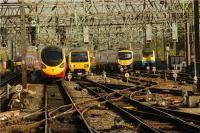 Looking south from the end of Platform 5 at Manchester Piccadilly over the approach to the station on 23 September 2009 as a Virgin Pendolino departs, a Northern Class 323 unit arrives, a FTPE Class 185 heads to the airport and an ATW Class 175 sits in the sidings awaiting it's next turn.<br><br>[John McIntyre 23/09/2009]