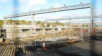 The new train maintenance sidings at Bathgate. The overhead lights are up, the platforms are built and the track is partly laid. [View through a chain-link fence thus the two vertical lines!]<br><br>[Ewan Crawford 26/09/2009]
