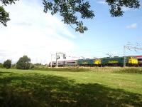 Freightliner duo 86614 & 86605 are seen being overtaken by a northbound Virgin Pendolino whilst held at signals south of Winsford Station on 1 September 2009. <br><br>[David Pesterfield 01/09/2009]