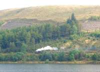 A Brecon Mountain Railway service, headed by an American outline tender locomotive, heads north from Pontsticill alongside Torpantau reservoir. The narrow gauge BMR follows the track bed of the old standard gauge Brecon and Merthyr line, which closed in 1962.<br><br>[Mark Bartlett 19/09/2009]