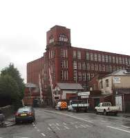 The old L&YR signalbox at Shaw and Crompton station is dwarfed by the adjoining mill building. With the closure of the Oldham Loop on 3 October 2009 for tram conversion this box disappeared and the crossing and tram movements are now controlled remotely. [See image 44395]<br><br>[Mark Bartlett 30/09/2008]