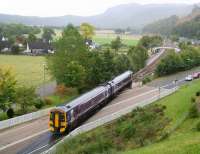 158708 on the level crossing over the A835 about to run into Garve station during a downpour on 1 October 2009. The train is the 1443 Kyle of Lochalsh - Inverness.<br><br>[John Furnevel 01/10/2009]