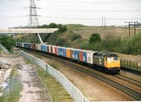 A class 47 with an Intermodal working runs alongside the former Midland main line at Goose Hill Junction, Normanton, in April 1988, heading towards Wakefield.<br><br>[David Pesterfield 23/04/1988]