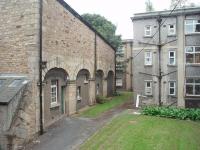 The view out from the rear of the original terminus of the Lancaster and Preston Junction Railway, only used as such from 1840 to 1849. The old trackbed area is now occupied by relatively modern hospital buildings. Of interest is what appears to be a stable block, possibly associated with the railway station but also probably used after that time when the station building became a private home. The old station was given to the Lancaster Infirmary as a Nurses' Home in 1924. This view looks south and the goods yard that survived the station closure until the 1960s was just beyond the far buildings. The stables building fronts onto the A6 main road immediately south of the city centre. Photo taken with the kind permission of the Morecambe Bay Hospital Trust Estates Department. <br><br>[Mark Bartlett 25/09/2009]