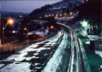 Northbound DMU approaching Tirphil on a <brass monkeys> winter evening circa 1988. Notice the jiggles in the DMU headlight trail - let alone in the car brake light trails on the left! There were sheep on the platform, but they haven't come out - they moved during the 30-second exposure.<br><br>[Ken Strachan /12/1988]