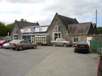 The former Corwen Station, with the station building now the sales office of Ifor Williams Trailers. The platform & trackbed area are used to display new trailers and provide servicing & spares facilities. Note the large glass frontage to the former entrance / waiting area through the centre of the building.<br><br>[David Pesterfield 07/05/2009]