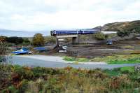 The morning service from Inverness passes south through Erbusaig with only a short distance left to reach Kyle of Lochalsh. The train came through the narrow cleft in the cliff above the right hand side of the right carriage. There are signs of recent embankment stengthening works. The view looks towards the Crowlin Islands. <br><br>[Ewan Crawford 01/10/2009]