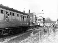 The <I>Rossendale Farewell Railtour</I> from Manchester Victoria is halted at Ramsbottom, for the level crossing gates to be opened, on its outward journey to Rawtenstall. The enthusiast with cine camera at the second door of the DMU is the late Fred Young, well known among the active members involved in the early days of the E.L.R. Preservation Society. The land in the foreground of this picture is now occupied by the reconstructed Up platform built after the East Lancashire Railway reopened [See image 49258]. <br><br>[Mark Bartlett 14/02/1981]