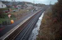 Dunlop, looking south. Since the photograph (1987) the line has been re-doubled and the second platform re-built. Note the old stone goods shed (then in use for a building company) in the background and lack of modern housing estate. Also the trees were quite a bit smaller! The trackbed appeared pretty diesel soaked - this was back in the days of the 47s on the Glasgow - Dumfries - Carlisle service. For the present day view [see image 23681].<br><br>[Ewan Crawford 22/10/1987]