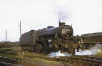 A bit of enthusiastic <I>bulling</I> has given Black 5 4-6-0 44971 a shiny smokebox for its last duties. The loco also has a full tender as it makes its way through the sidings at Lostock Hall shed. In the background is the scrap line containing many of 44971's already withdrawn sister engines and alongside is one of the Type 2 Class 25 Bo-Bo diesels that took over many of Lostock Hall's steam duties. <br><br>[David Hindle 02/08/1968]