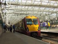 334023 at Platform 15 of Glasgow central waiting to depart on a working to Ayr on 19th May 2009. In the background in the now closed car park is the mock up of the new Siemens Class 380 Desiro which will be appearing from September 2010 onwards.<br><br>[Graham Morgan 19/05/2009]