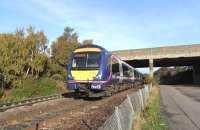 During weekend diversion of Edinburgh - Glasgow services on 17 October a 6-car Class 170 accelerates towards Edinburgh following a lengthy wait in the Up Loop at Dalmeny where it reversed.To the right is the trackbed of the Ratho to South Queensferry branch, rather overshadowed (in both senses) by the Forth Bridge when it opened in 1890.Though 'goods only' for decades it survived long enough to need to be crossed by this bridge carrying the A90 Forth Road Bridge approach which opened in 1964.In fact I believe the branch was used to transport materials for the bridge construction. <br>
<br><br>[David Panton 17/10/2009]