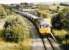 I loved the Oakdale coal trains when I lived in Gwent. The 56's made dramatic noises going downhill or up, and the tramroad converted to a railway had curves, tunnels, disused stations, the lot. This dramatic view (notice the offset platforms, one to the right of the loco') was taken in the final year of operations. The trackbed has been cut by a new road.<br><br>[Ken Strachan /06/1989]