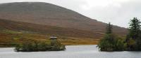 A westbound service approaches the closed Glencarron Platform on 30 September as it passes by Loch Sgamhain. <br><br>[Ewan Crawford 30/09/2009]